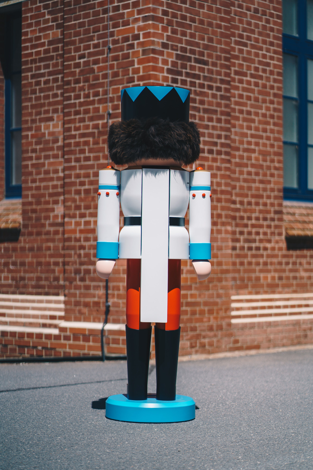 The rear view of a large figure (large nutcracker) can be seen. This one looks at a wall in the background.