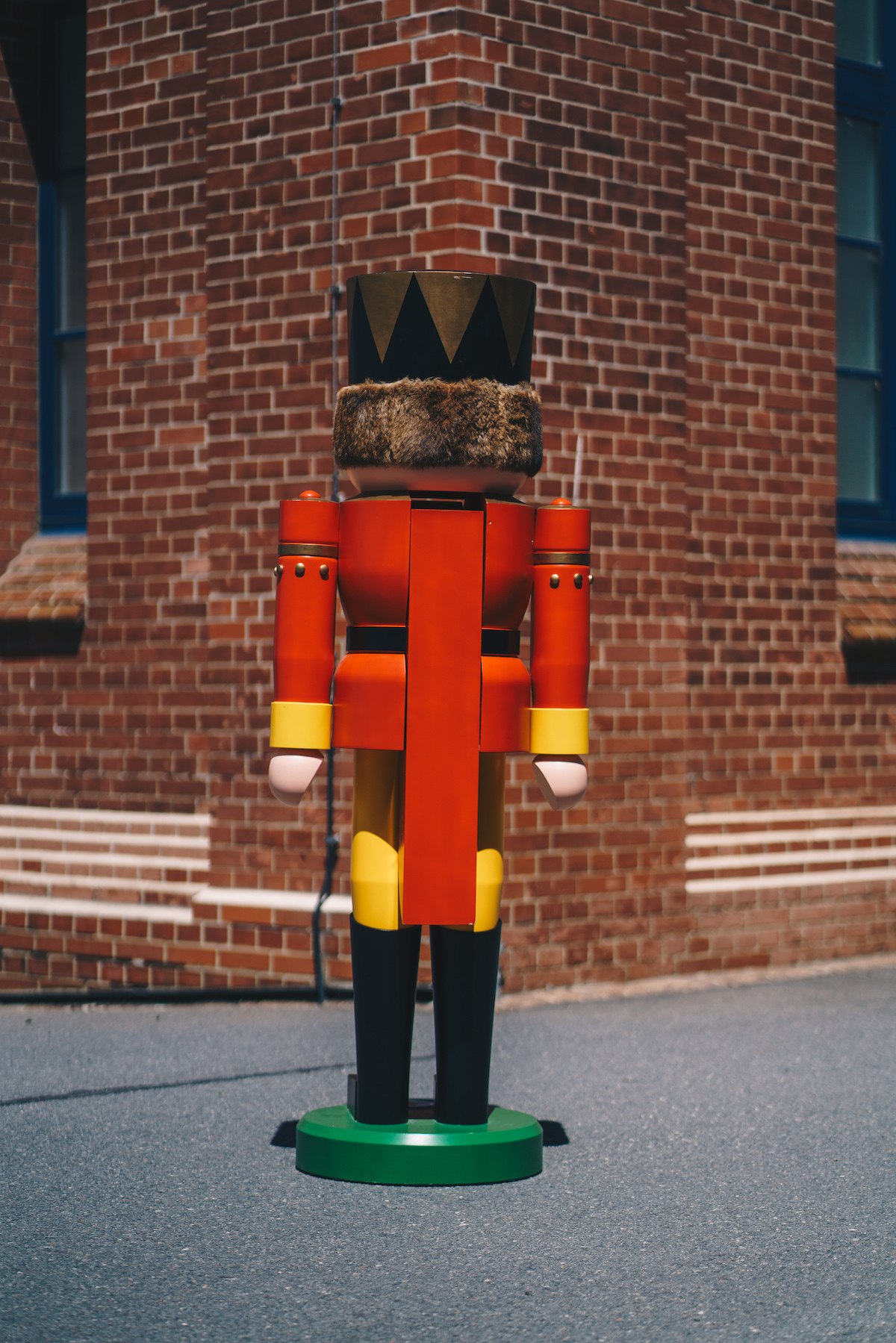 The rear view of a large figure (big nutcracker) can be seen. This looks on a wall in the background.