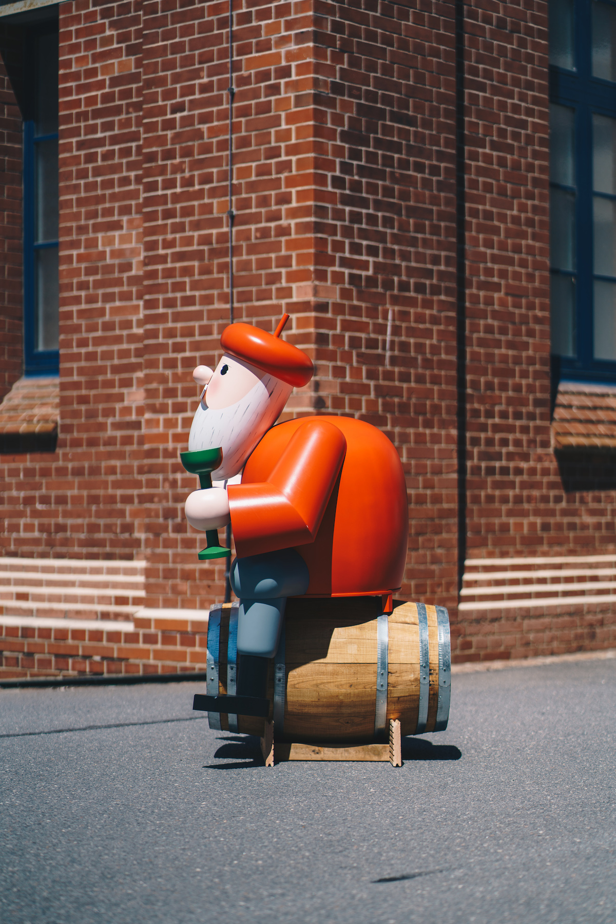 The picture shows the side view of a huge smoker model winemaker from the Ore Mountains. The figure sits on a wine barrel and looks to the left.